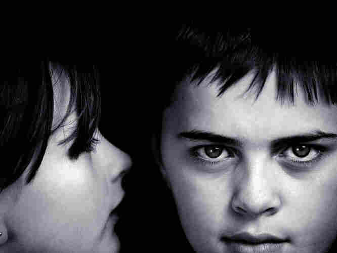girl whispers to boy